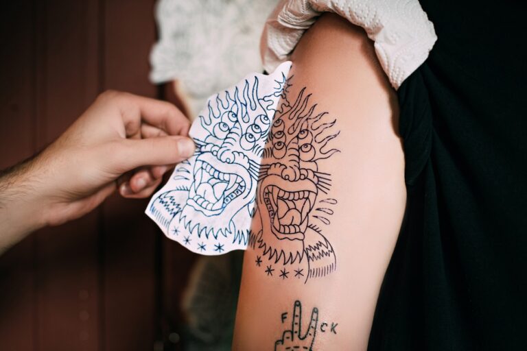 Tattoo artist applying a stencil before tattooing in Hurghada