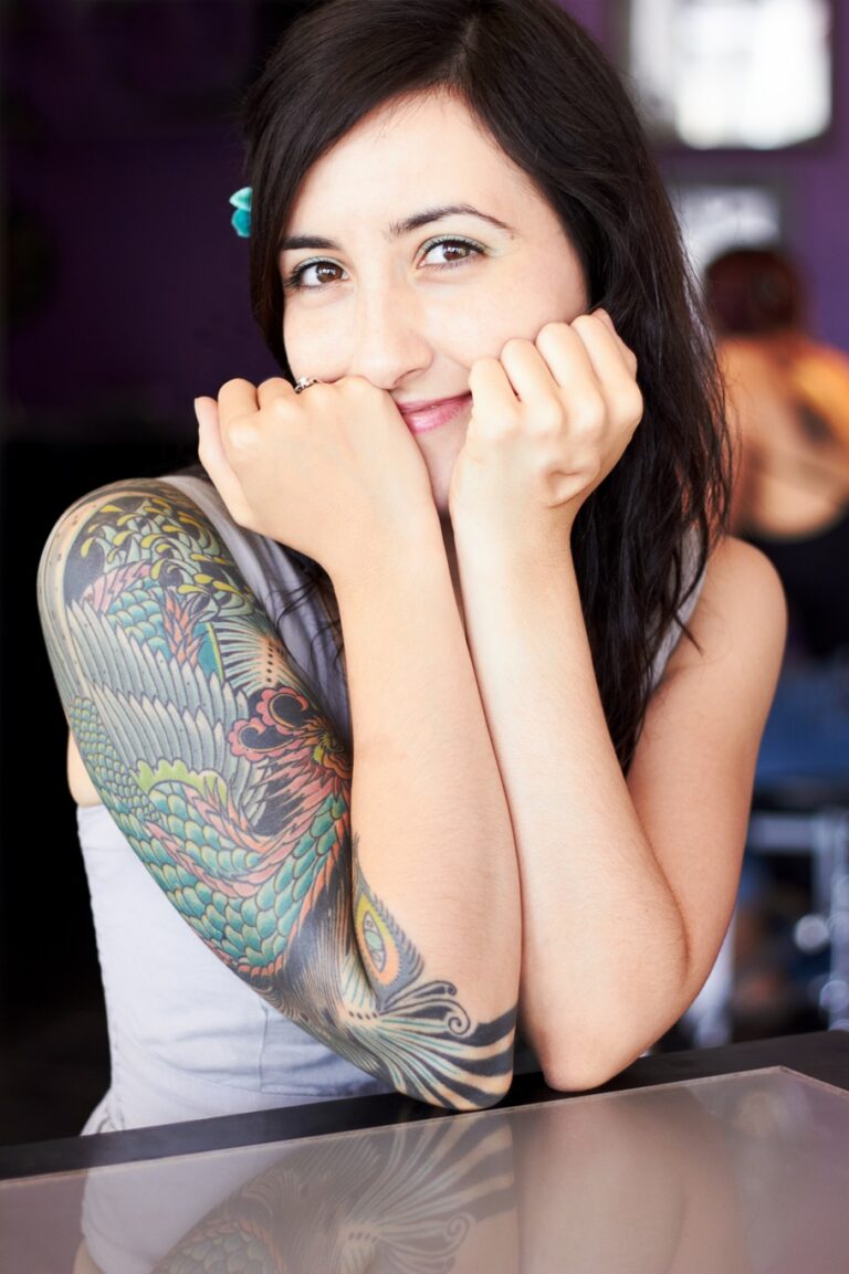 Tattooed woman smiling with a color sleeve tattoo