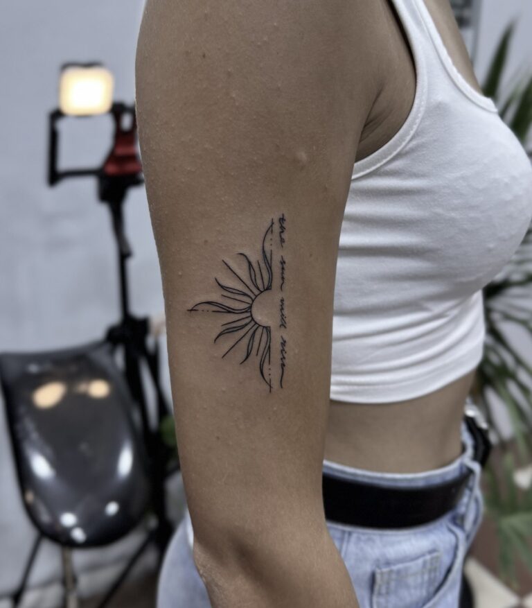 Fine line sun tattoo on upper arm