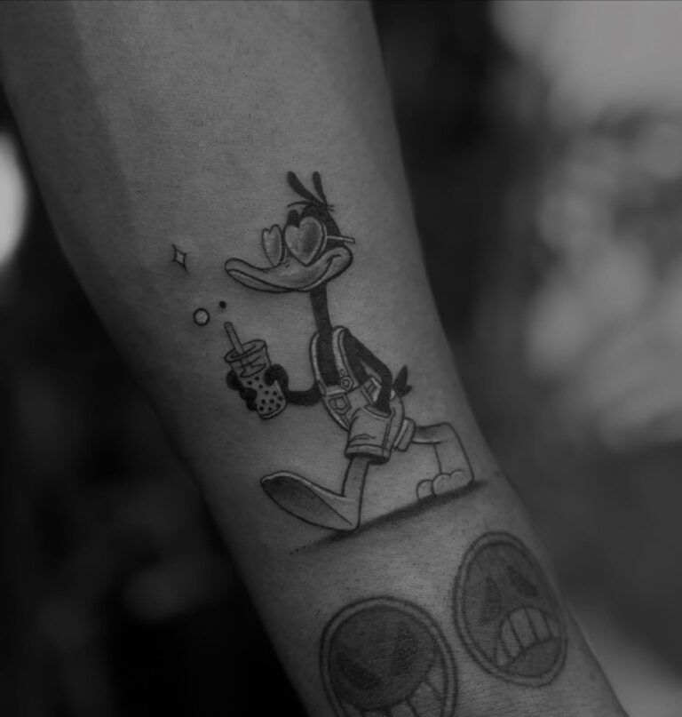 Black and grey cartoon duck tattoo on forearm by DR G Tattoo Hurghada