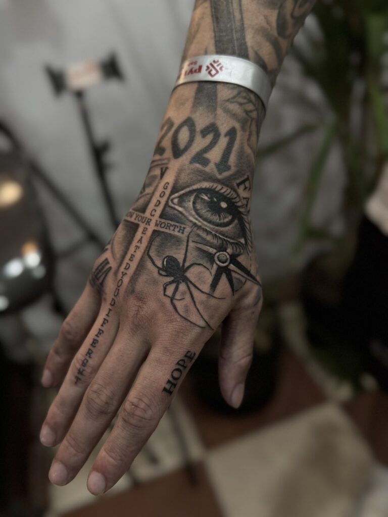 Hand and wrist tattoo with 2021 lettering and Egyptian eye