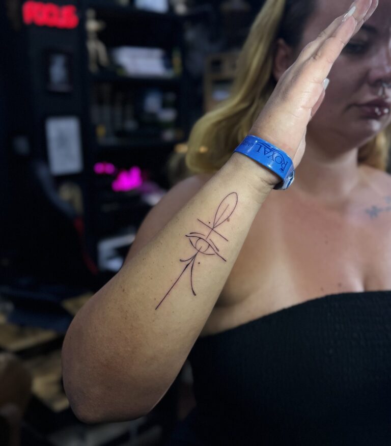 Fine line ankh and lotus forearm tattoo on a holiday guest in Hurghada