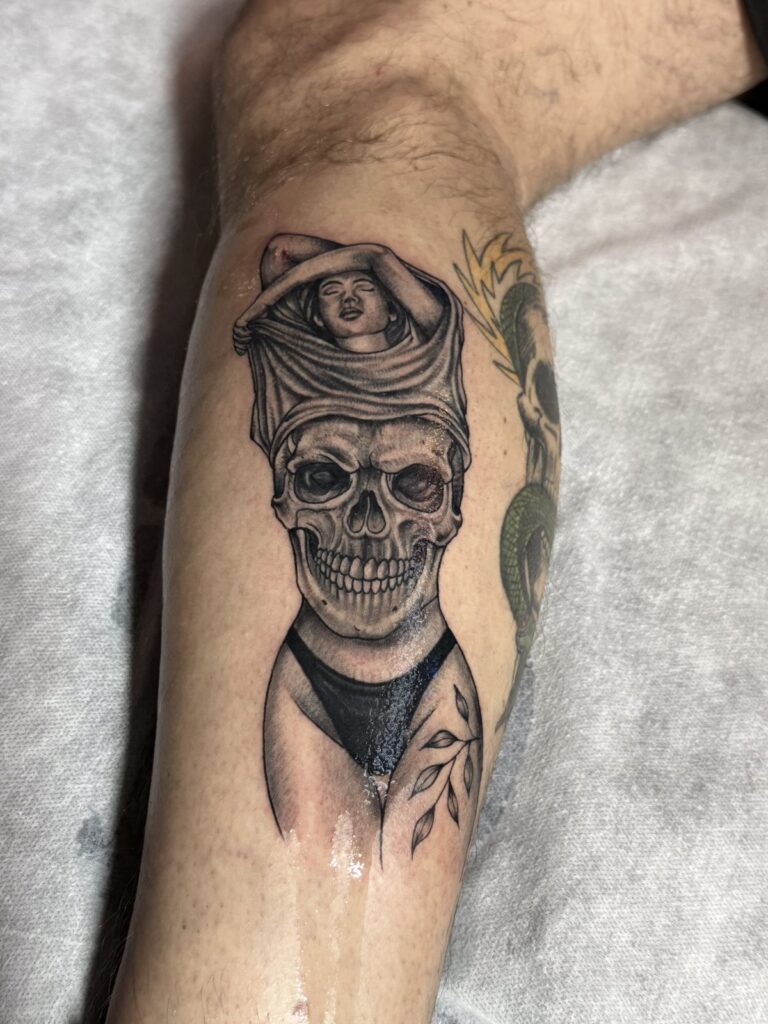 Skull with Eye of Horus headdress calf tattoo – black and grey realism