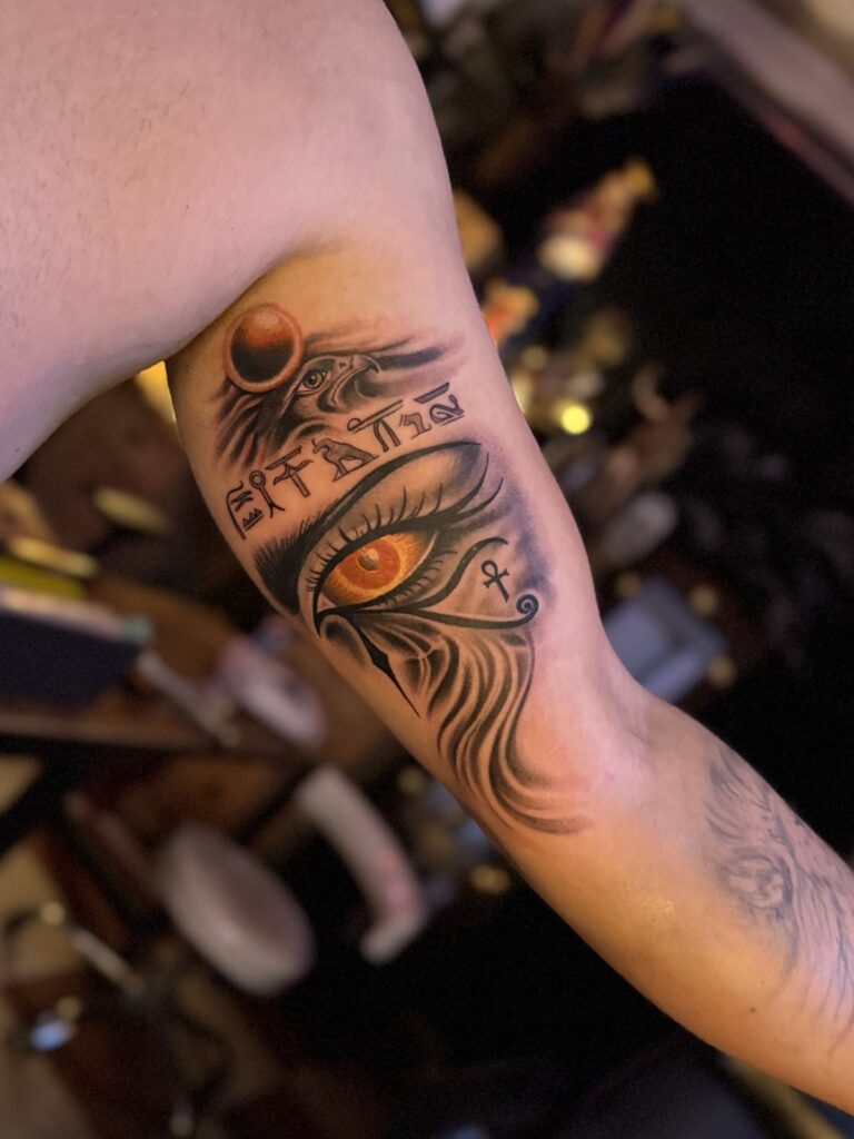 Eye of Ra realism tattoo on upper arm, healed close-up – DR G Tattoo Hurghada